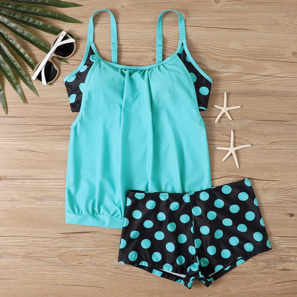 Women's black polka dot high-waist swimsuit with conservative briefs style on a mannequin.