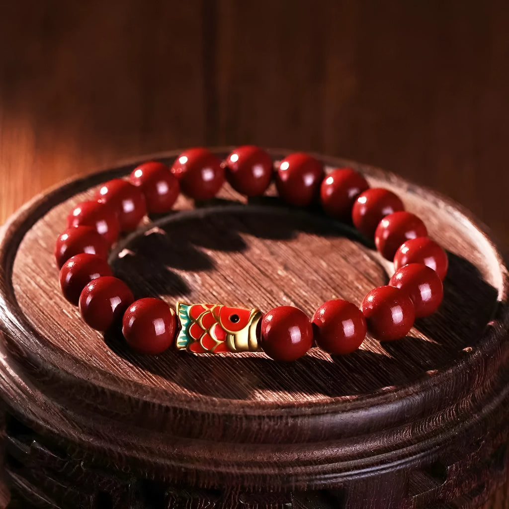 Natural cinnabar koi carp bracelet with gold ball in 4mm or 6mm size on wrist.