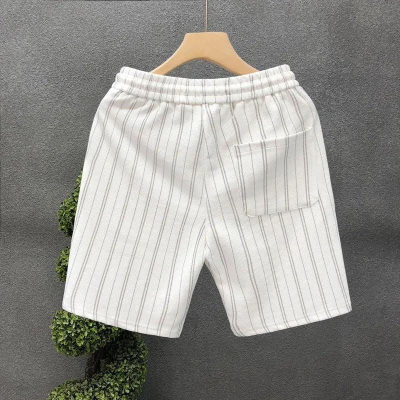 Men's black and white striped casual shorts with elastic waistband, shown on a hanger.