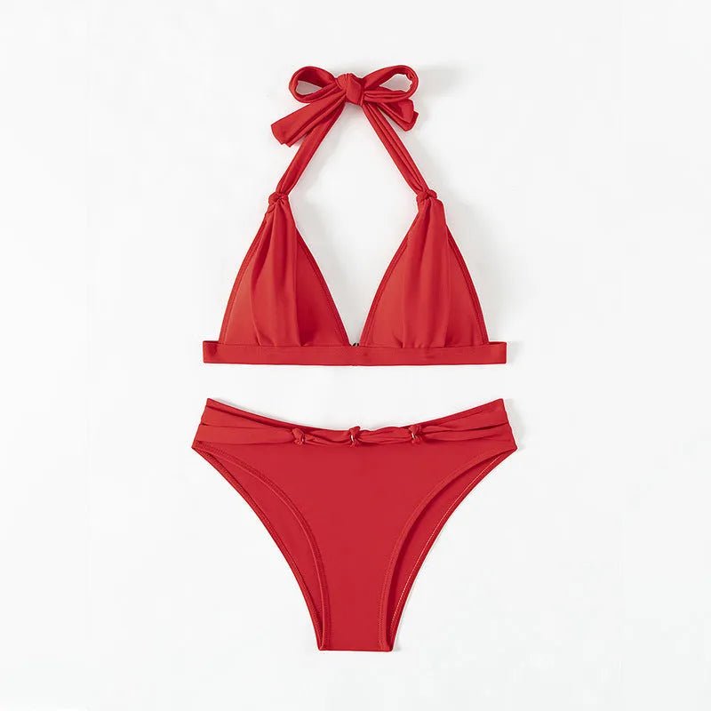 Red women's lace-up halterneck bikini top and matching shorts on a plain background.