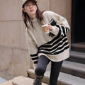 Beige winter maternity sweater with stand collar, loose fit, long sleeves, and striped plaid pattern on a woman