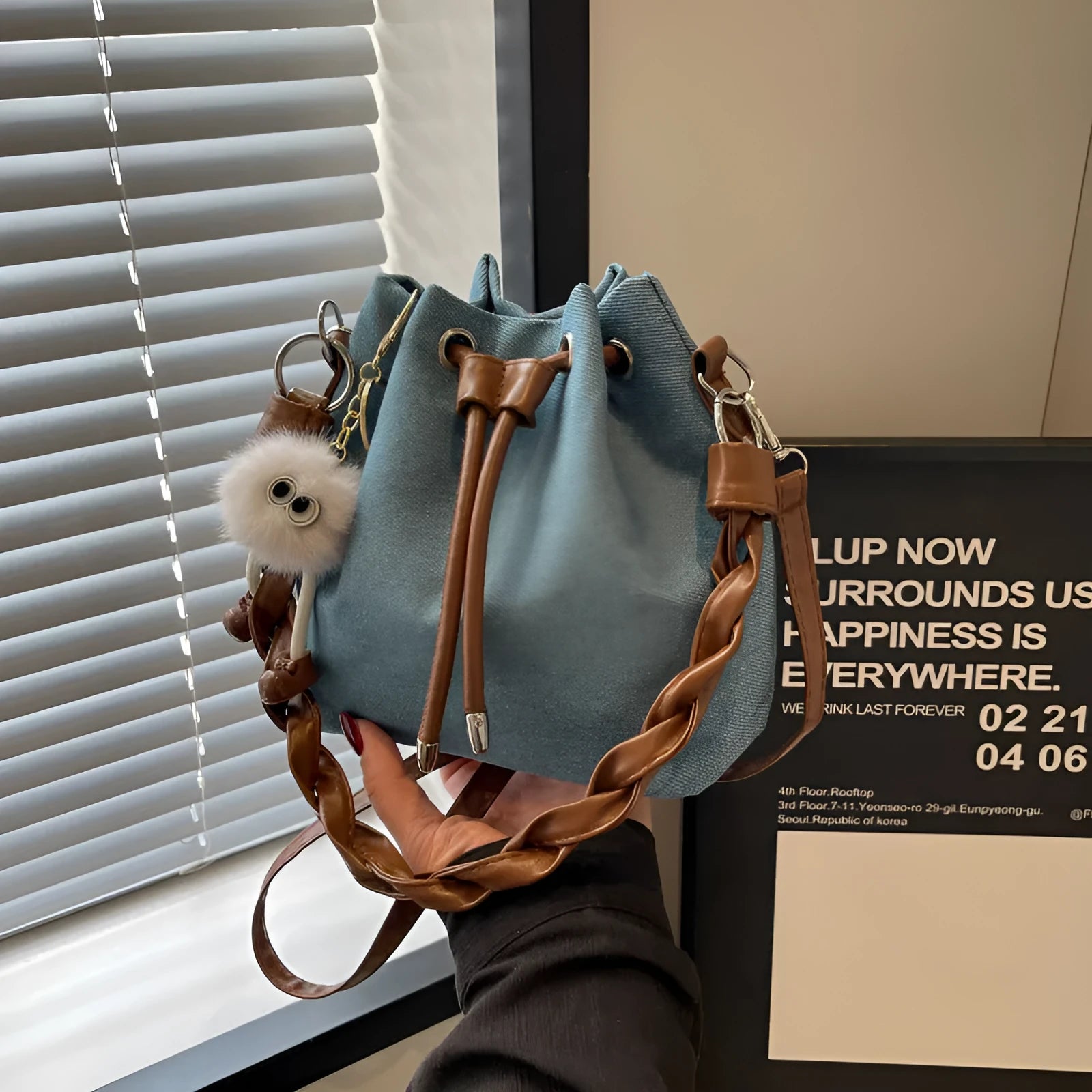 Blue cross body bucket messenger bag with synthetic leather construction
