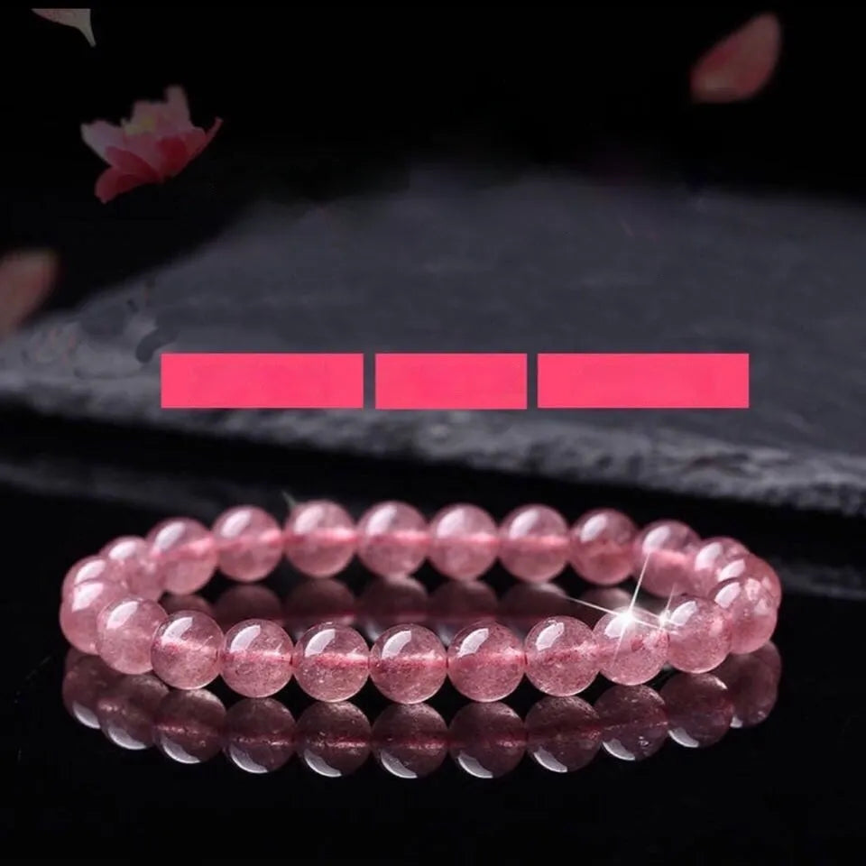 Women's bracelet with round, polished strawberry quartz crystal stones in natural pink tones.