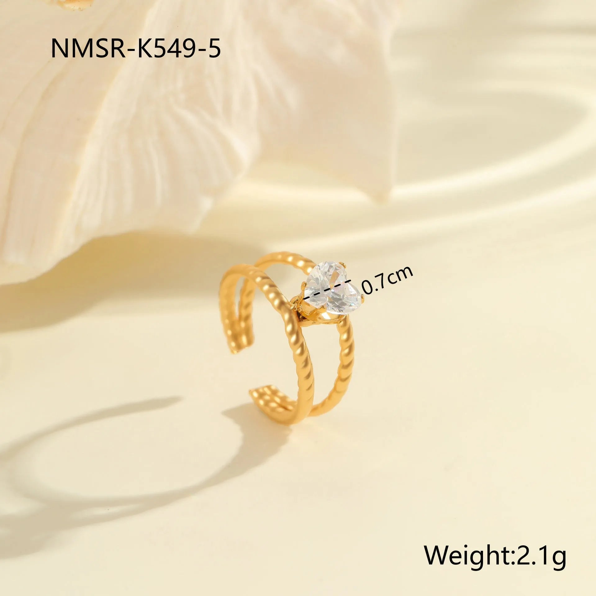 Gold-plated geometric stainless steel ring with inlaid zircon stones on a white background.