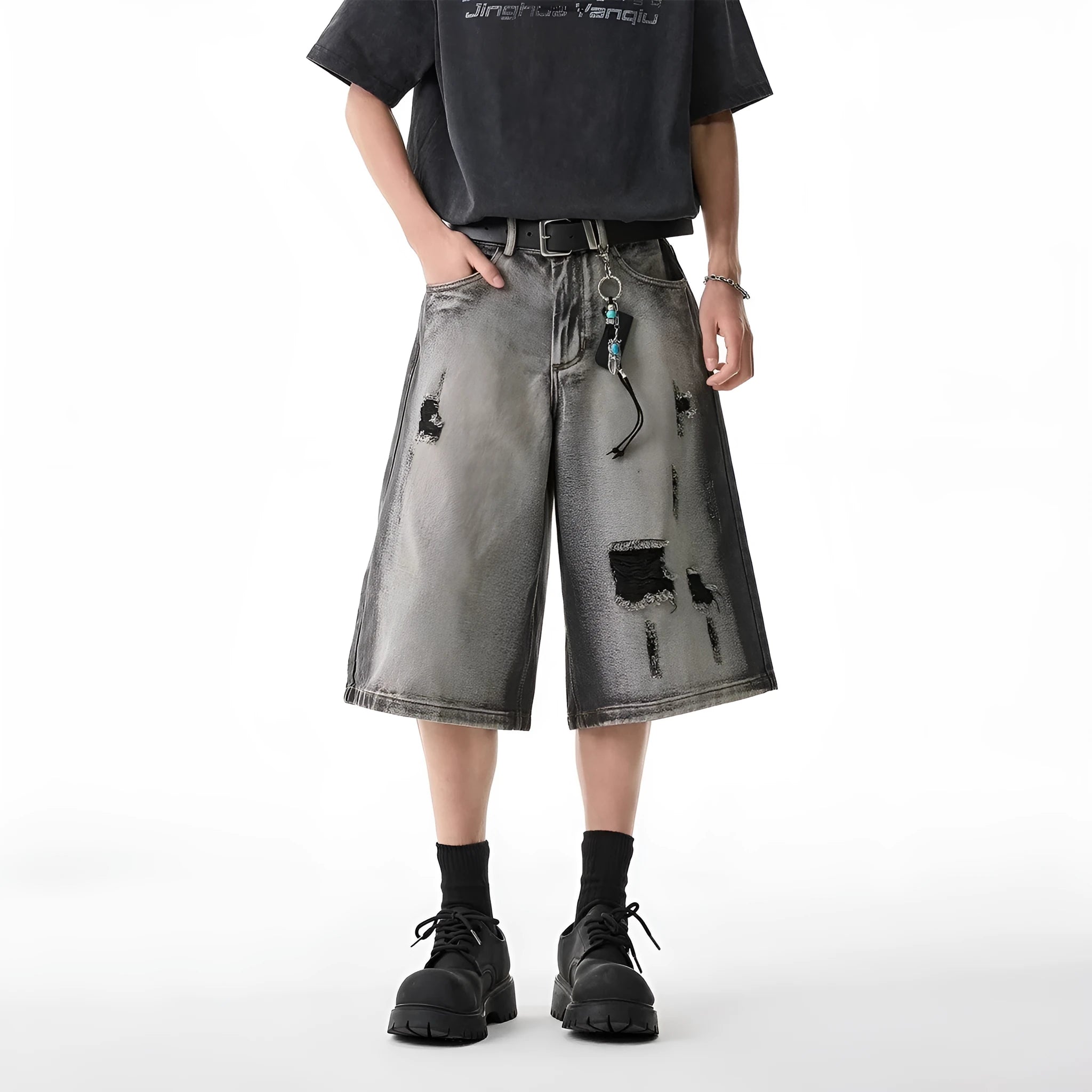 Gray distressed denim shorts with hole detailing, loose cropped fit on a plain background.