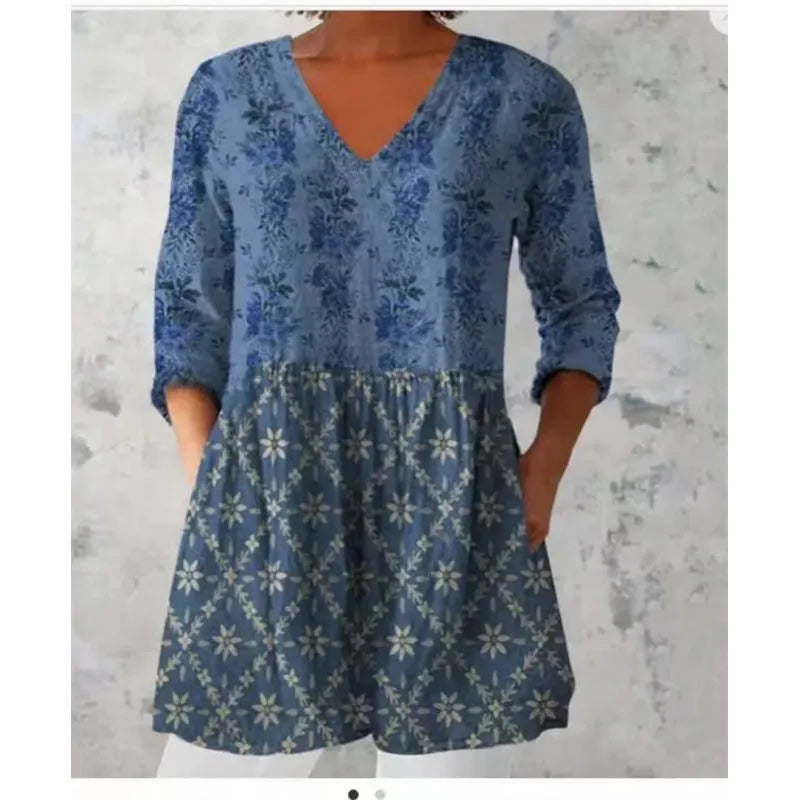 A woman modelling a printed, loose-fitting dress with a wide waist and three-quarter length sleeves.