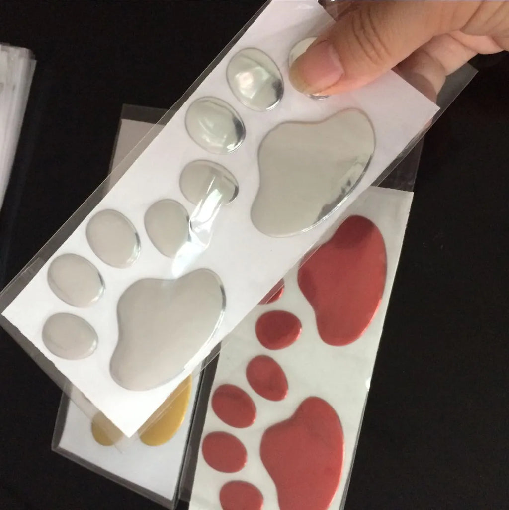 Pair of red dog footprint car stickers in a hand-shaped brush style on a white background.
