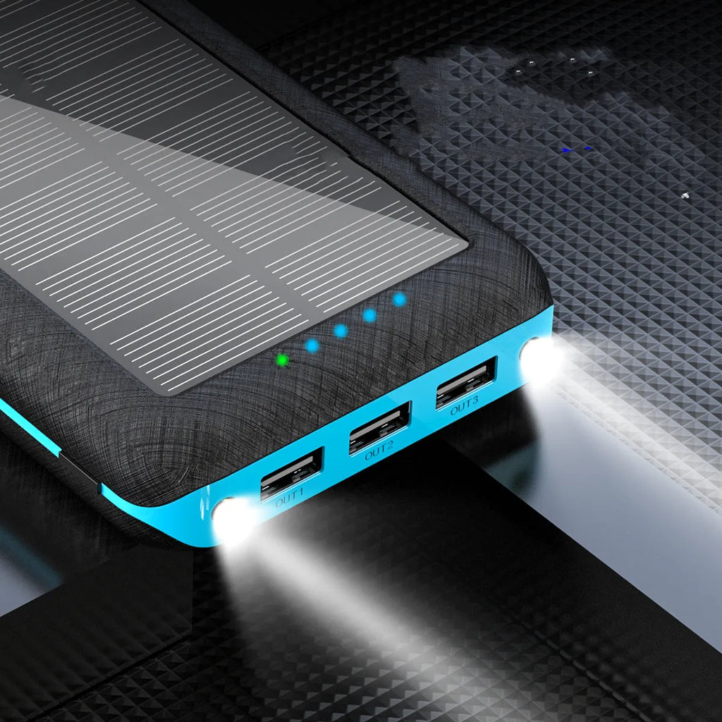 Black portable power bank with solar panel, wireless charging surface, and three USB output ports