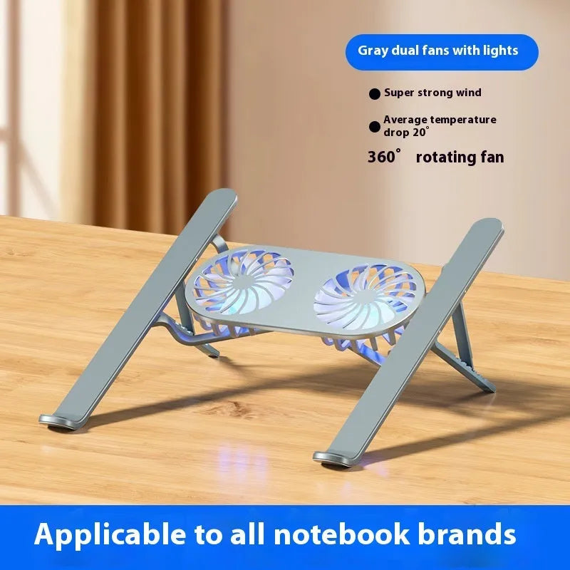 Silver aluminium laptop stand with twin fans raised at an angle on a wooden desk.