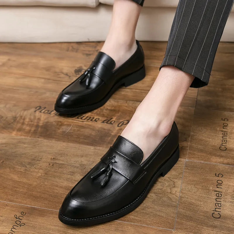 Men's black slip-on business casual shoe with a tassel detail on a low-top artificial PU upper.