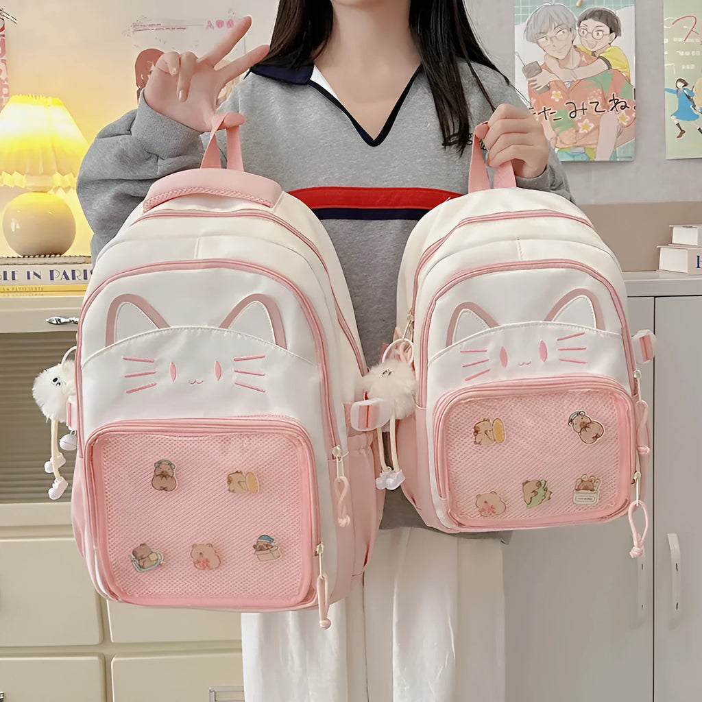 Cartoon print large capacity nylon backpack in pink with badge pendant, shown with curved shoulder straps.