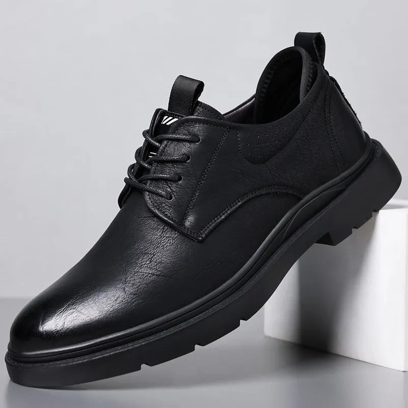 Men's black and brown leather casual sneakers with rubber sole and sewing line detail on the upper.