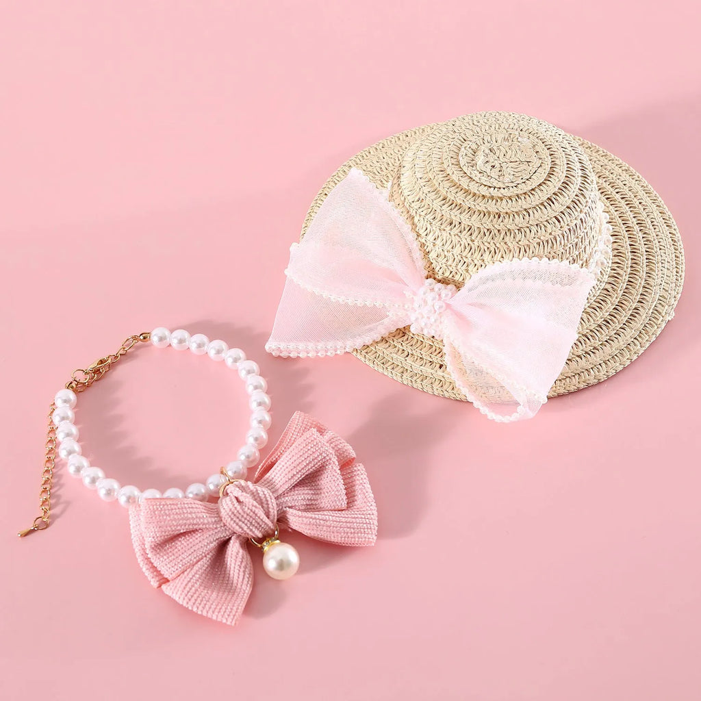 Woven straw hat for a cat with a pearl butterfly bow, shown in pink, purple, blue, or white colour options.