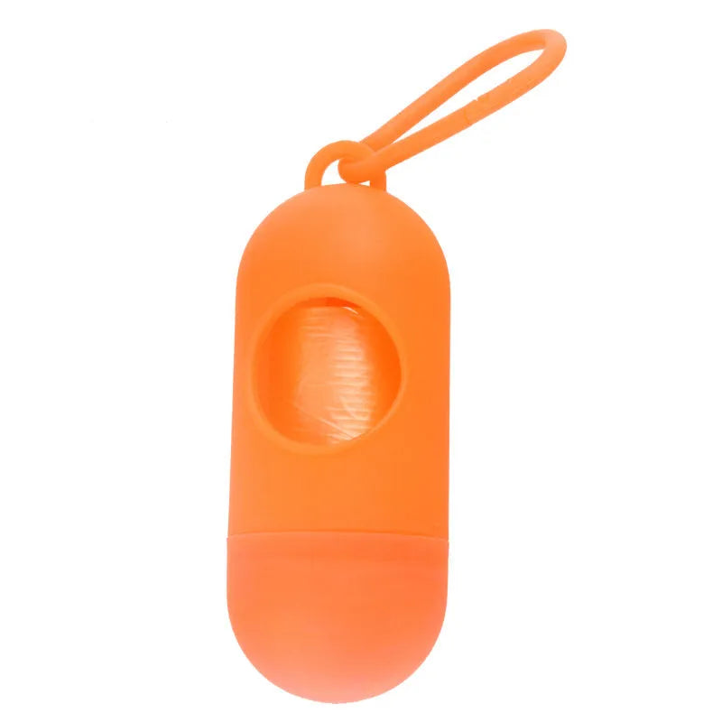 Compact black dog waste bag dispenser with a metal hook and Velcro strap, shown attached to a dog lead.