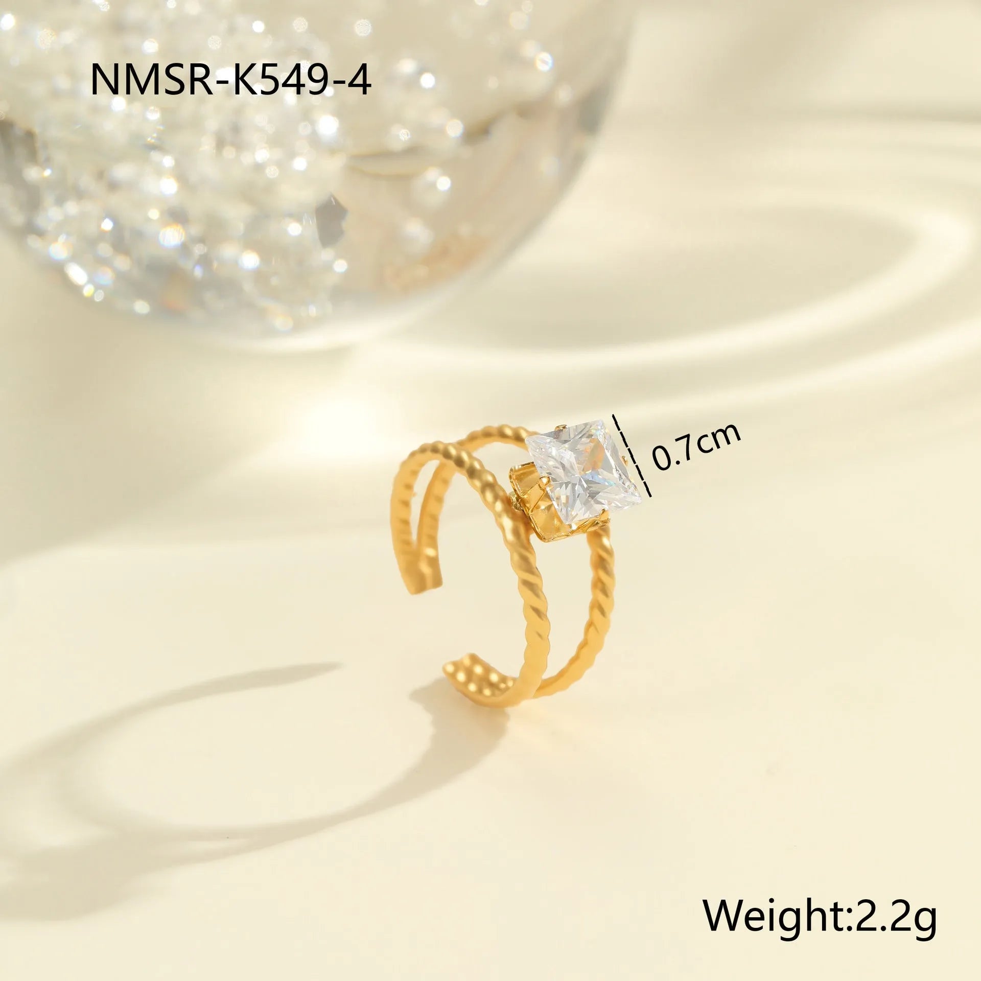 Gold-plated geometric stainless steel ring with inlaid zircon stones on a white background.