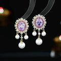 Oval geometric copper drop earrings with pearl elements, inlaid zircon treatment, and tassel detailing in light purple colour