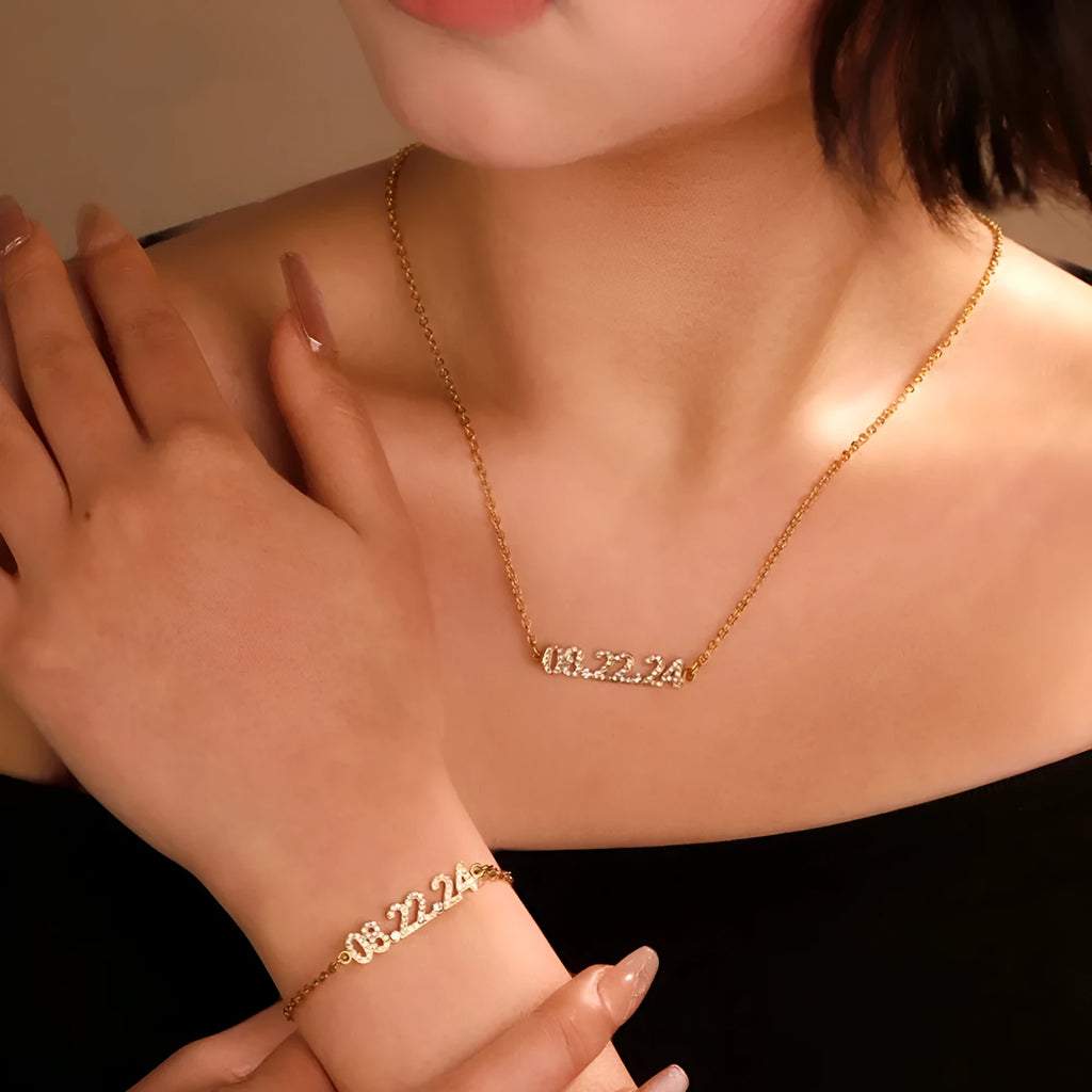 Stainless steel digital bracelet or necklace with diamond-set numbers on display, shown in gold colour.
