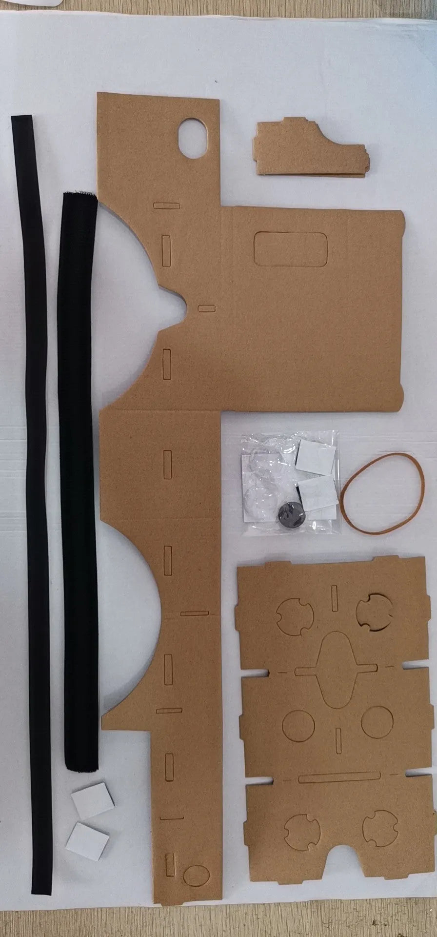 Pink and white cardboard VR glasses headset for smartphones, showing lenses, head strap, and magnetic button.