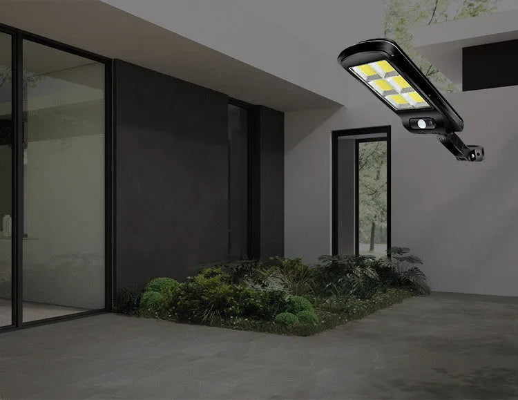 Black solar-powered outdoor motion sensor light mounted on a wall or post.