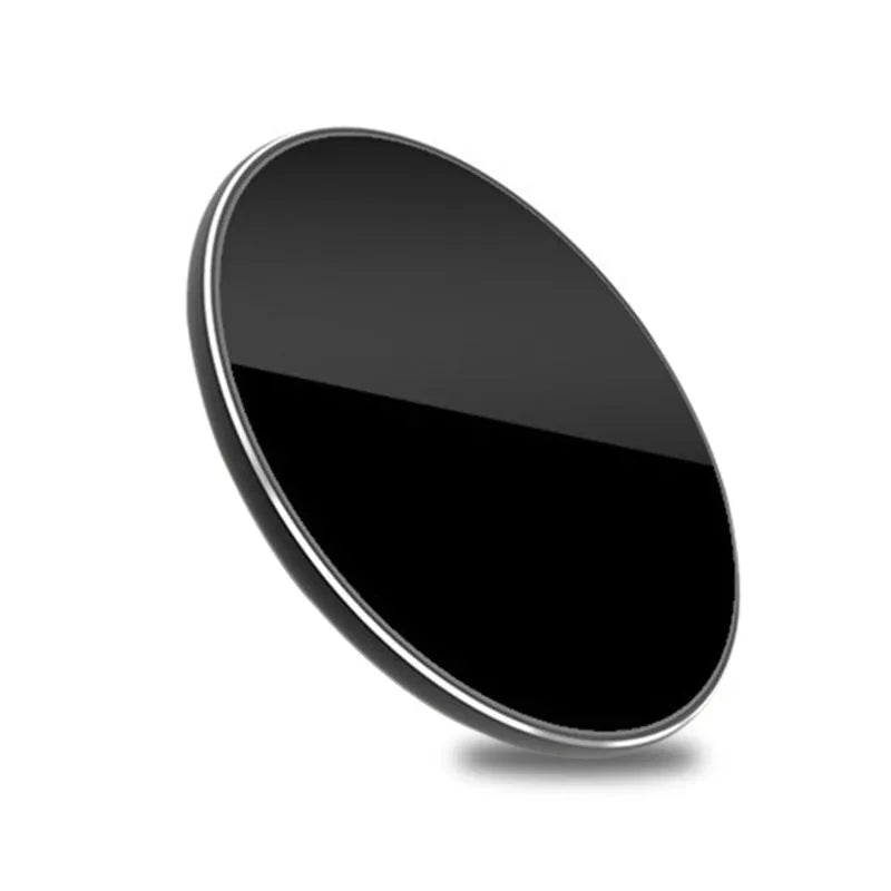 Ultra-thin aluminum wireless charger in silver on a desk next to a phone.
