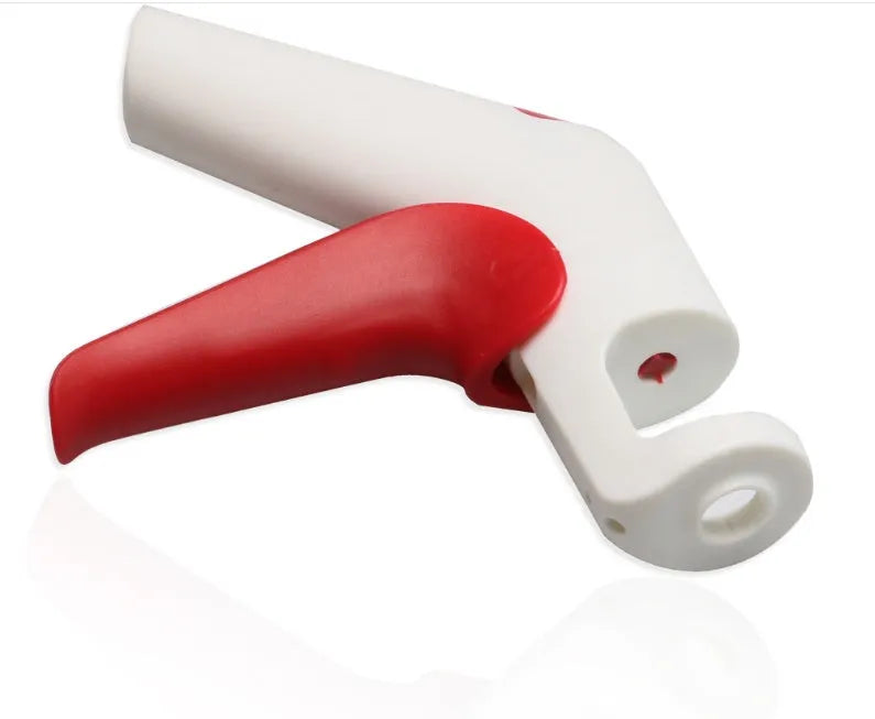 Manual handheld cherry kernel remover kitchen gadget with stainless steel blades and clear pit catcher.
