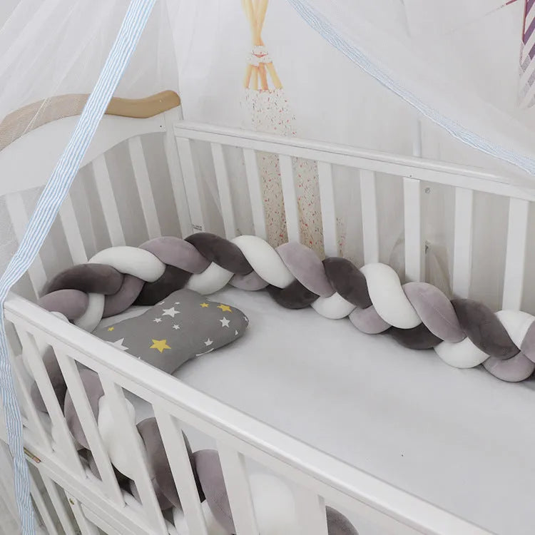 Soft spandex velvet braided knot crib bumper in a neutral colour, shaped around a cot.