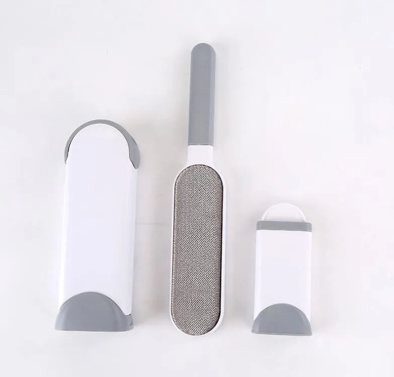 Blue reusable pet hair removal comb with double-sided brush head next to its self-cleaning base.