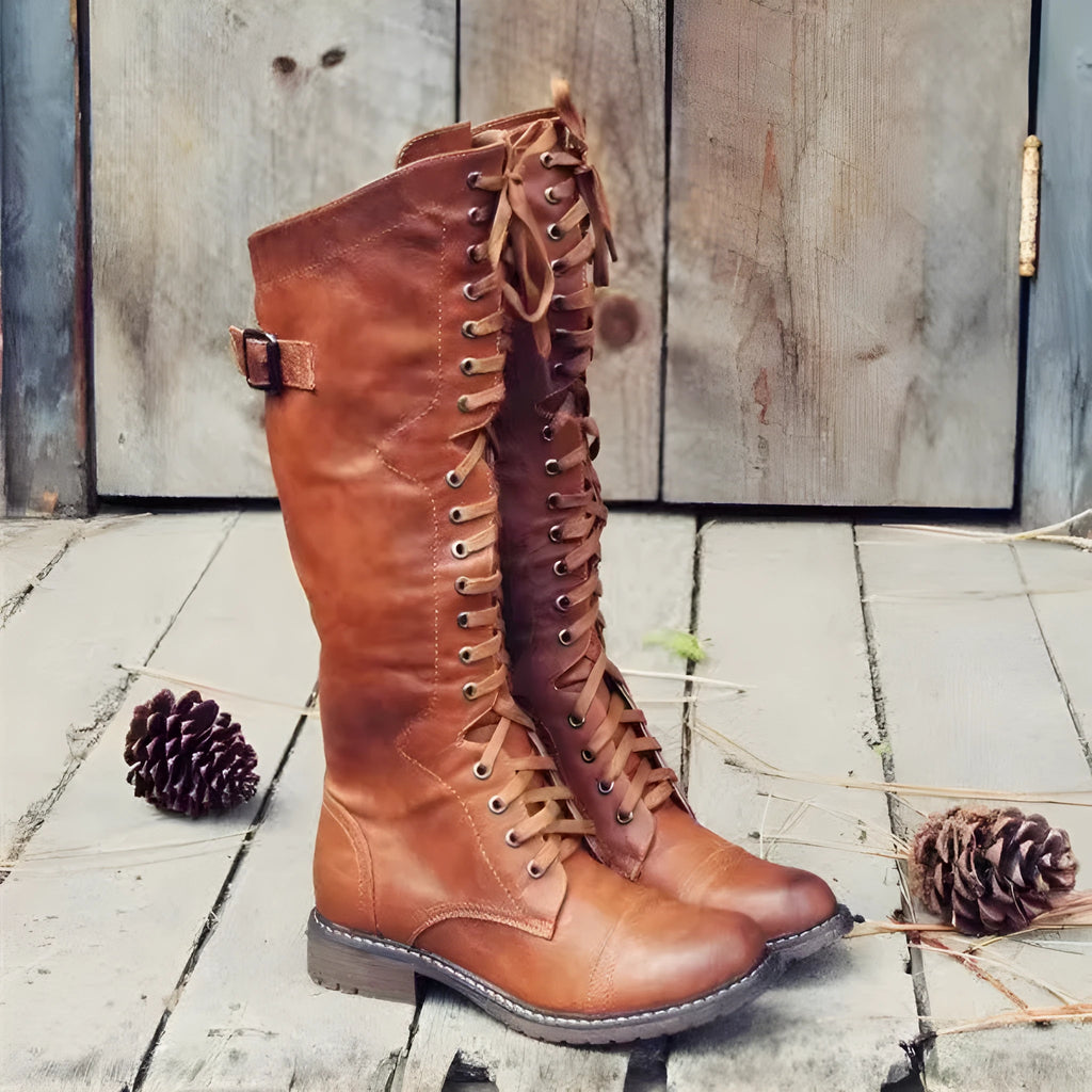 Women's black chunky heel high leg boots with a round toe on a plain background.