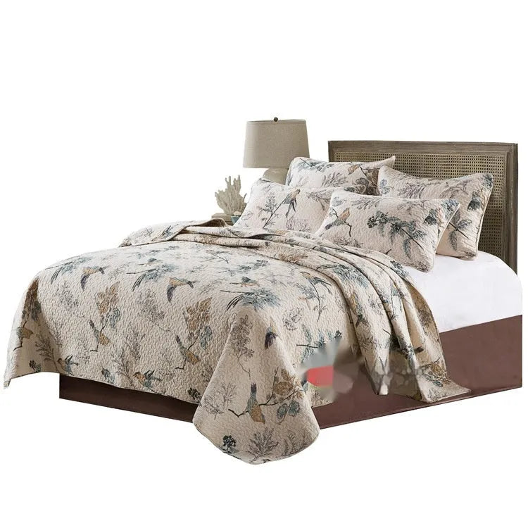 Quilted pure cotton bed cover set with printed pattern on a bed, includes two matching pillowcases.