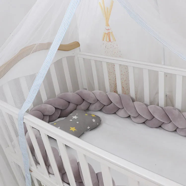 Soft spandex velvet braided knot crib bumper in a neutral colour, shaped around a cot.