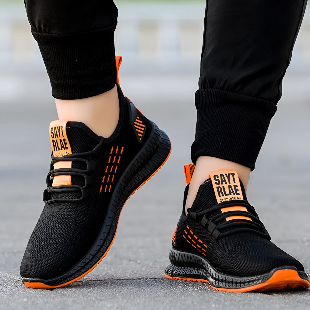 Men's low-top black casual sports shoes with cross strap detail and Flying Weave upper on a wear-resistant sole.