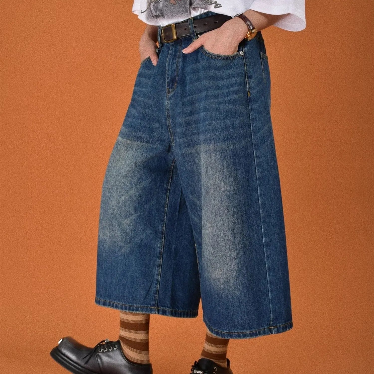 Men's loose straight-cut denim shorts in blue, shown on a hanger.