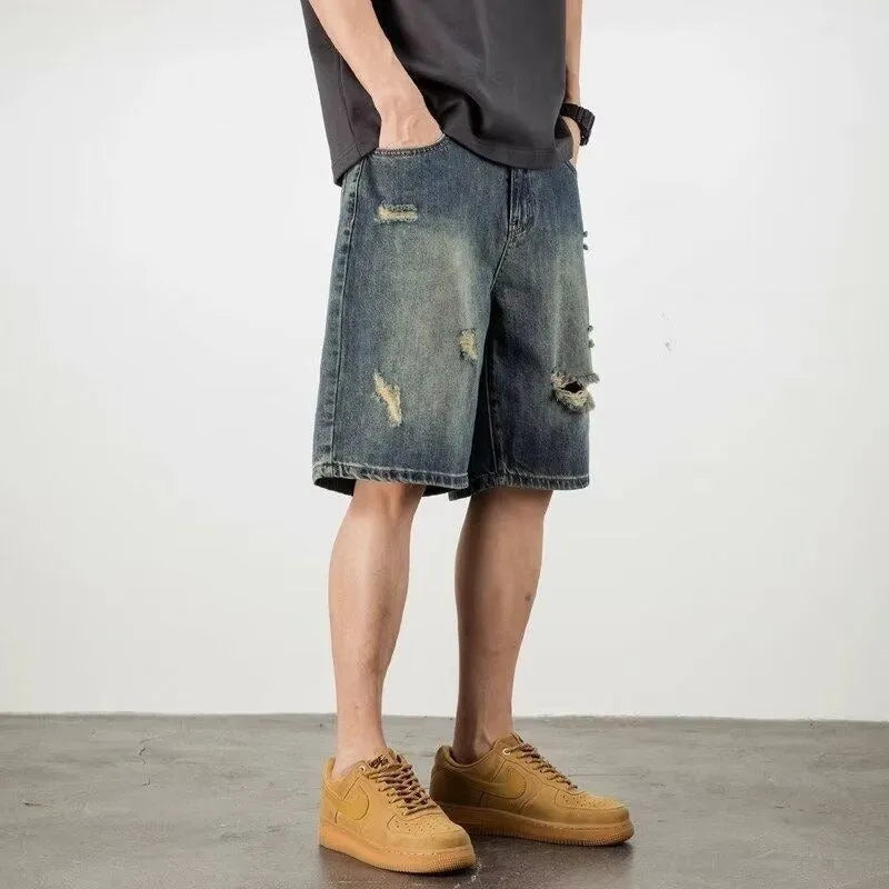 Men's blue denim shorts with loose hole distressing and straight leg silhouette