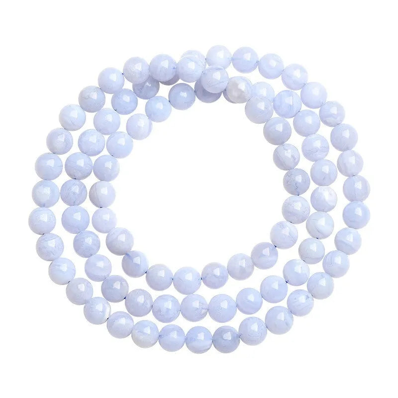 Blue agate bracelet with scattered beads pattern and a Ruyi charm on a white background.