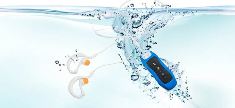 Compact black Bluetooth MP3 player with attached earphones, shown next to a USB cable.