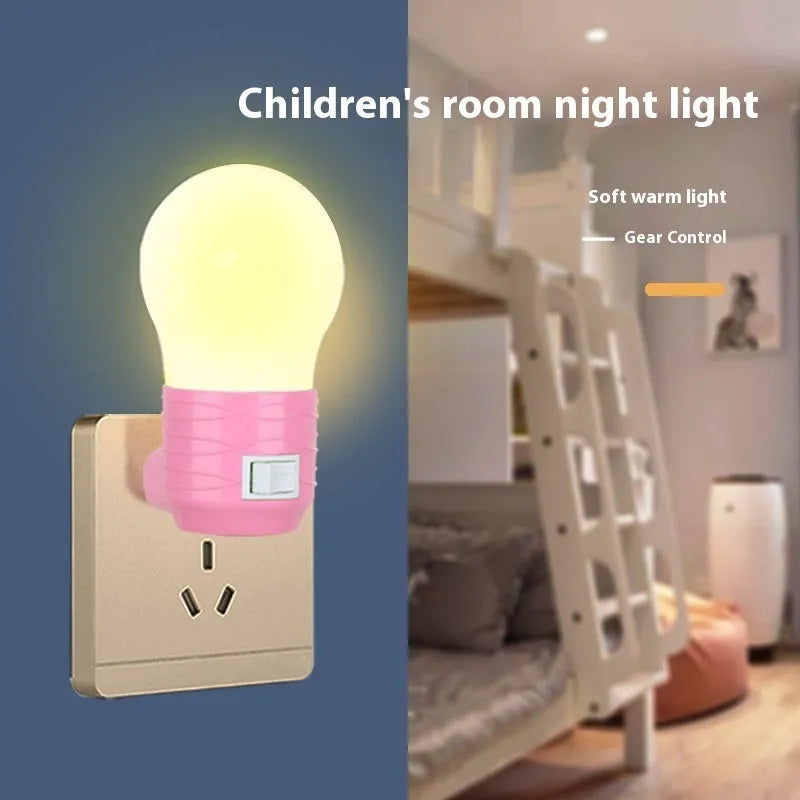Plug-in bedside baby night light in white, blue, or pink shell on a nursery table.