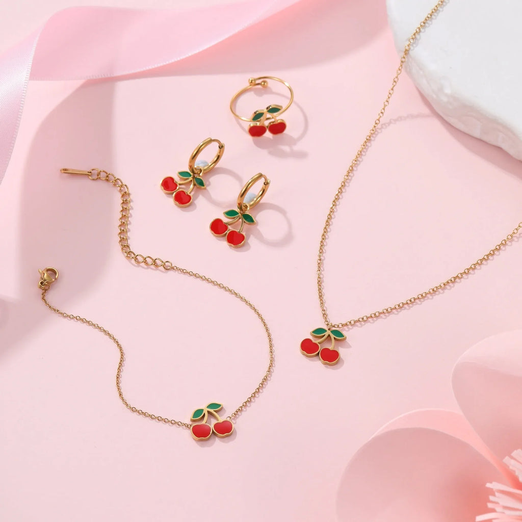 Cherry jewellery set showing necklace, bracelet, earrings, and ring in stainless steel with 18K electroplated finish