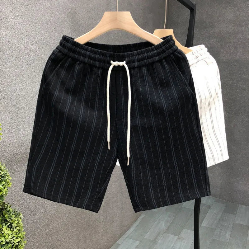 Men's black and white striped casual shorts with elastic waistband, shown on a hanger.