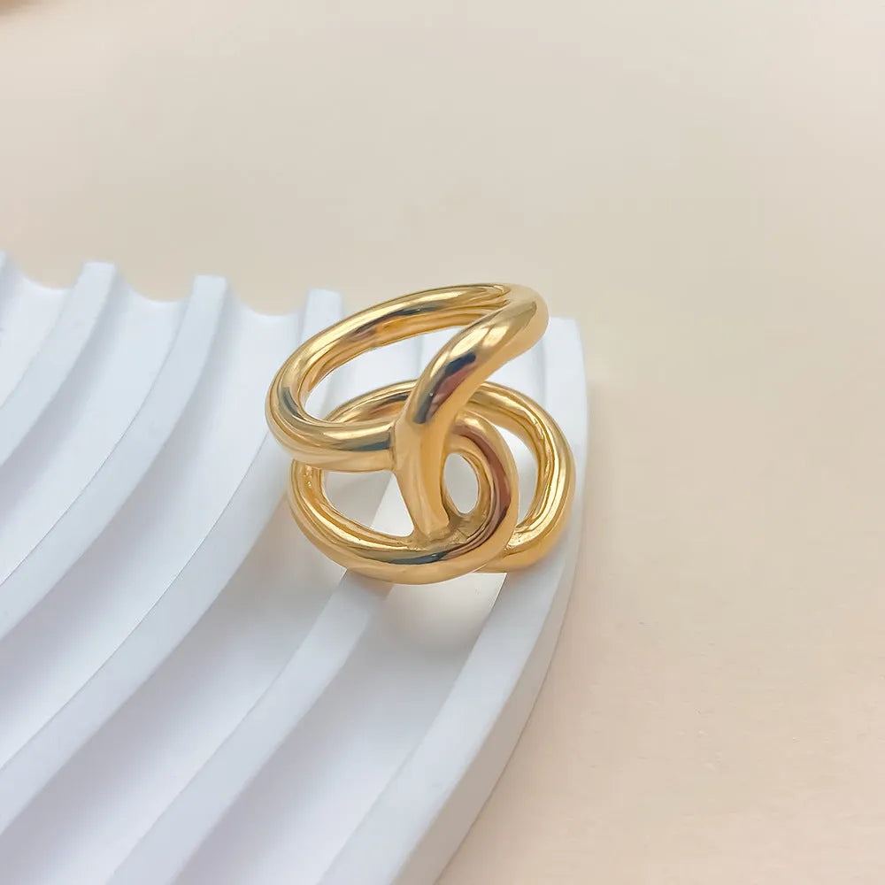 A geometric knotted adjustable ring for women in stainless steel, shown in gold and steel colour finishes.