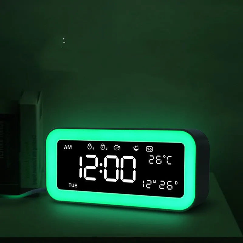 Blue rectangular LED alarm clock with atmosphere lighting on a wooden desk.