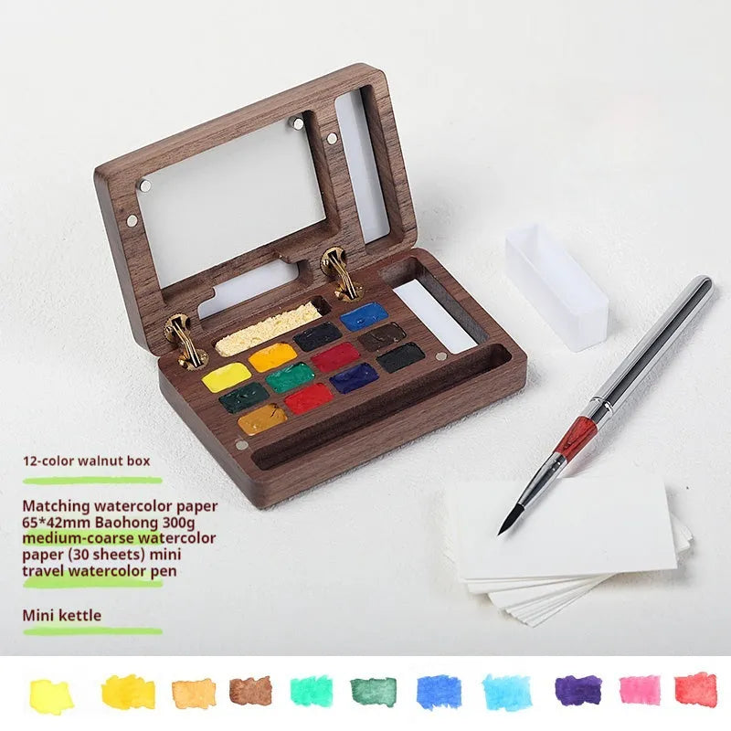 Mini walnut wood watercolour paint box open to show pigment pans with leather carrying bag