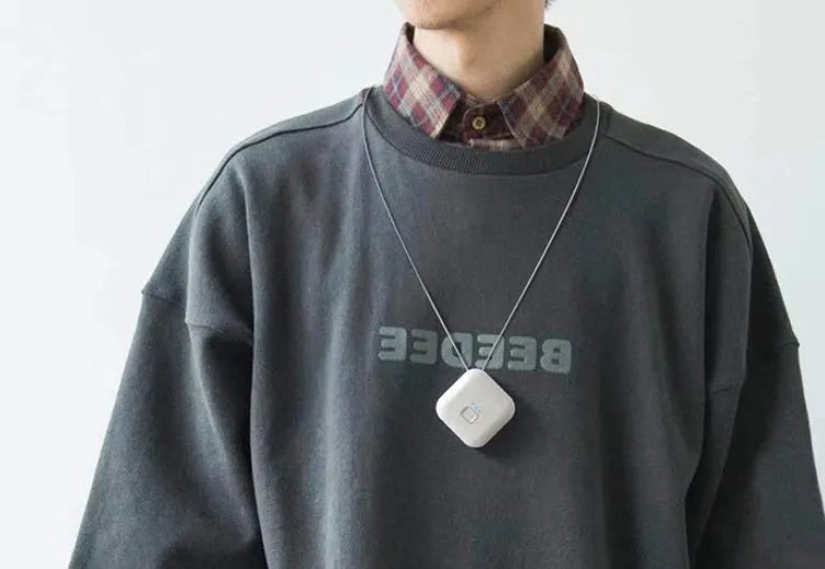 Mini USB portable air purifier necklace in pink, showing compact wearable design.