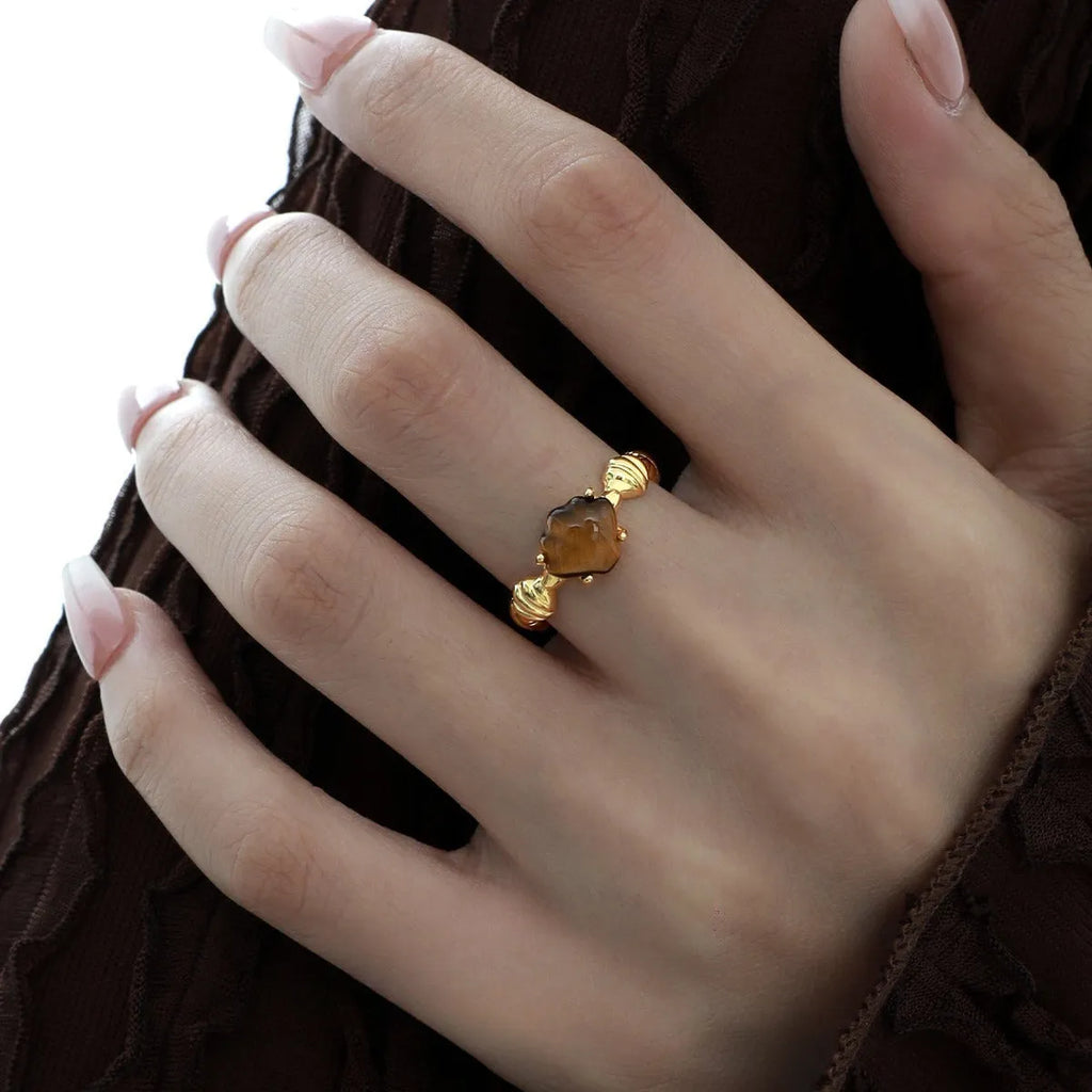 Women's adjustable silver ring with sculpted shell design and tiger eye stone in gold finishes