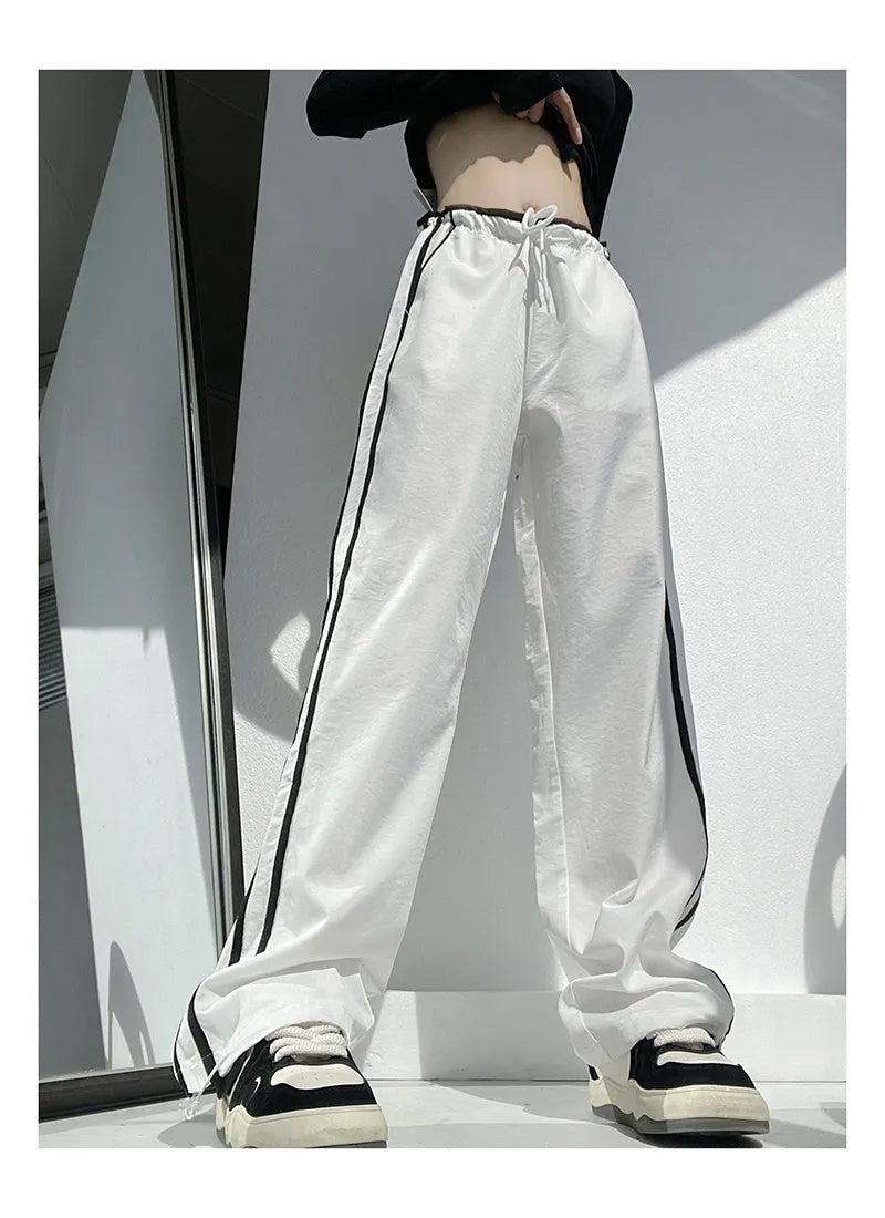 Women's navy blue loose straight-leg trousers with thin fabric and ribbon parallel bars contrast detail.
