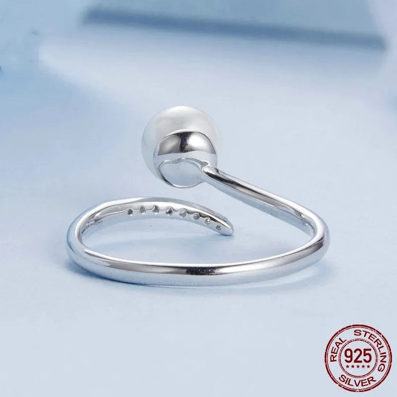 Adjustable sterling silver ring with natural shell pearls and open loop design