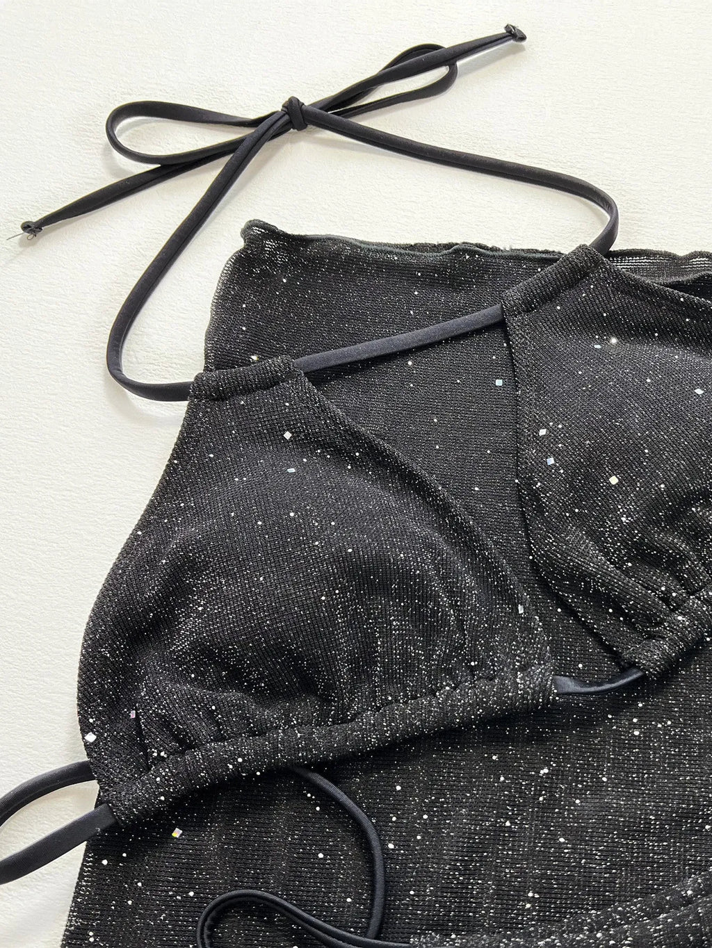 Black three-piece bikini swimsuit set with top and shorts on a mannequin