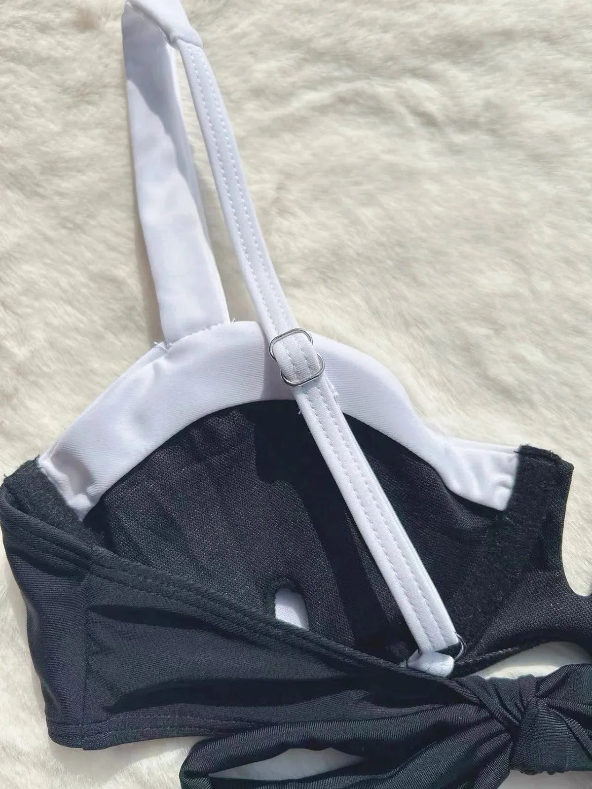 Black low-waist women's bikini swimsuit with stitching detail on a mannequin