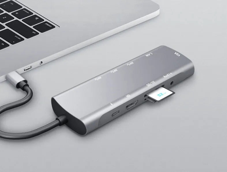 Grey aluminium USB-C docking station with HDMI, VGA, USB ports and a short connecting cable
