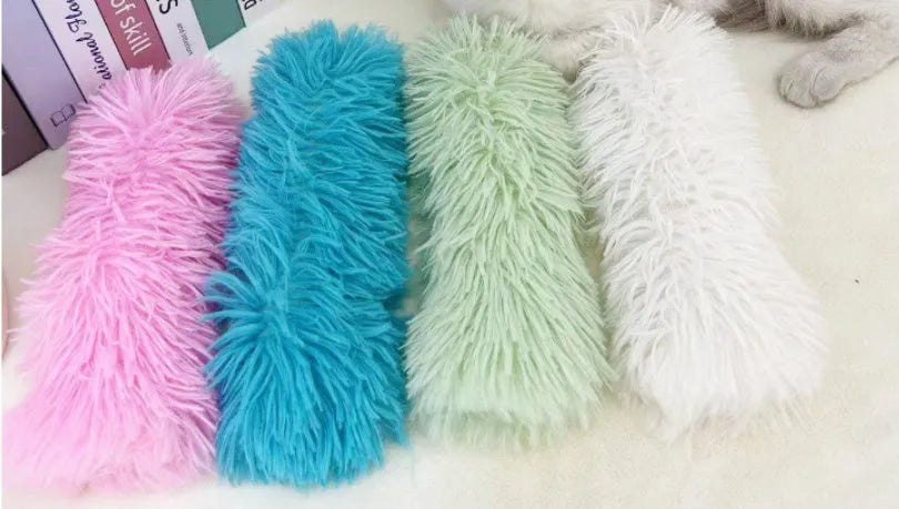 Soft plush cat toy pillow in blue, green, pink, or white, measuring 27 by 10 centimetres.