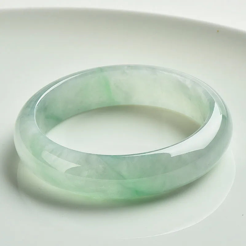 Light green jade bracelet showing natural stone texture with sizing chart displaying 53mm to 64mm circumference options